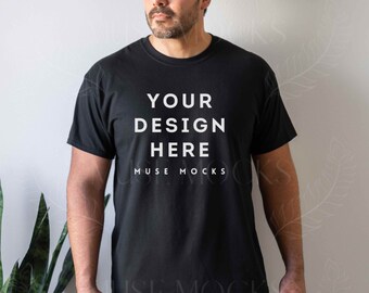 May include: A black t-shirt with the text "YOUR DESIGN HERE" and "MUSE MOCKS" printed on the front.