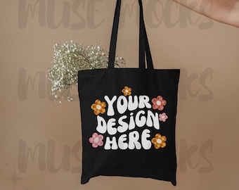 May include: Black tote bag with white text that says "YOUR DESIGN HERE" and colorful flower graphics.