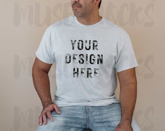 May include: A light gray t-shirt with the text "YOUR DESIGN HERE" printed in black on the front. The shirt is being worn by a person with a beard.