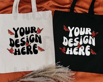 May include: Two tote bags with butterfly designs. One bag is white with black text and the other is black with white text. Both bags say "Your design here".