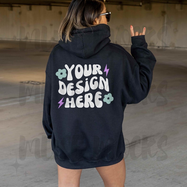 Op de afbeelding: Zwart hoodie met de tekst "YOUR DESIGN HERE" in wit met een paarse bliksem en groene bloemen op de rug.