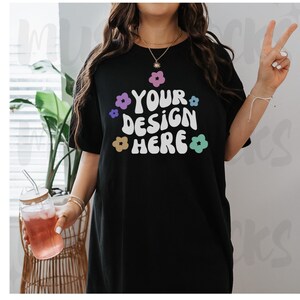 May include: Black oversized t-shirt with a white graphic that says "YOUR DESIGN HERE" surrounded by colorful flowers.