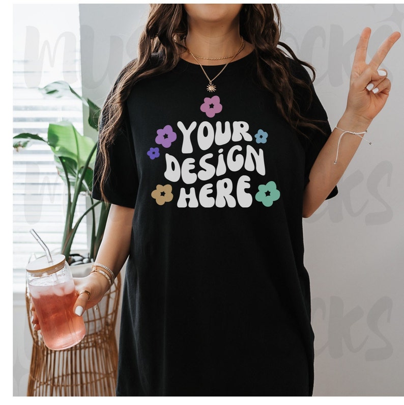 May include: Black oversized t-shirt with a white graphic that says "YOUR DESIGN HERE" surrounded by colorful flowers.