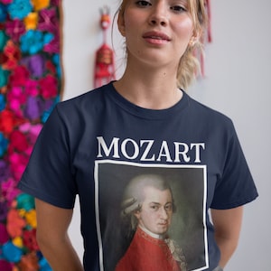 May include: A navy blue t-shirt with a white print of Mozart's portrait and the word "MOZART" above it.