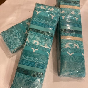 May include: Three packages of teal blue fabric strips with various patterns, including floral, geometric, and abstract designs. The fabric is wrapped in clear plastic.