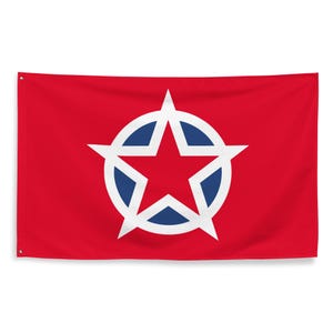 May include: A rectangular red flag featuring a central emblem consisting of a solid red five-pointed star outlined in white, set against a dark blue circular background. The flag includes metal grommets in the top and bottom left corners.