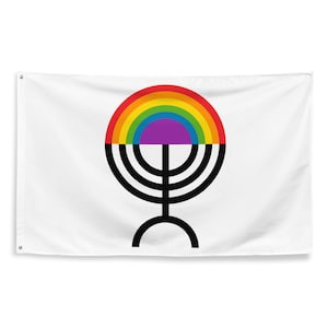 Op de afbeelding: Een witte vlag met een regenboogcirkel boven een zwart menorah-symbool. De regenboog bestaat uit rood, oranje, geel, groen, blauw, indigo en violet. De menorah heeft zeven takken en een basis.