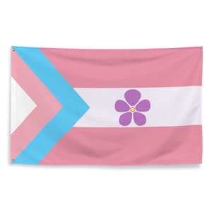 Może przedstawiać: Różowa, biała i niebieska flaga dumy osób transpłciowych z fioletowym kwiatem z żółtym środkiem w środku.