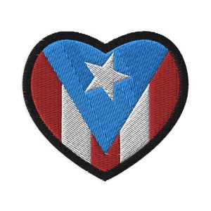 May include: A red, white, and blue heart-shaped patch with the Puerto Rican flag design. The flag features a white star on a blue field with red and white stripes.