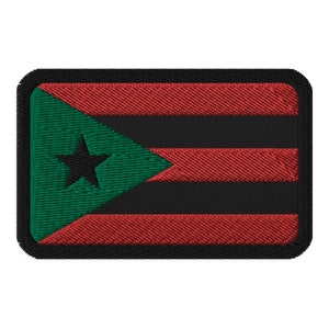 May include: A black, red, and green embroidered patch with a white star in the green triangle. The patch has a black border.