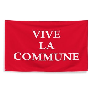 Może przedstawiać: Czerwona flaga z napisem "VIVE LA COMMUNE" nadrukowanym na biało.