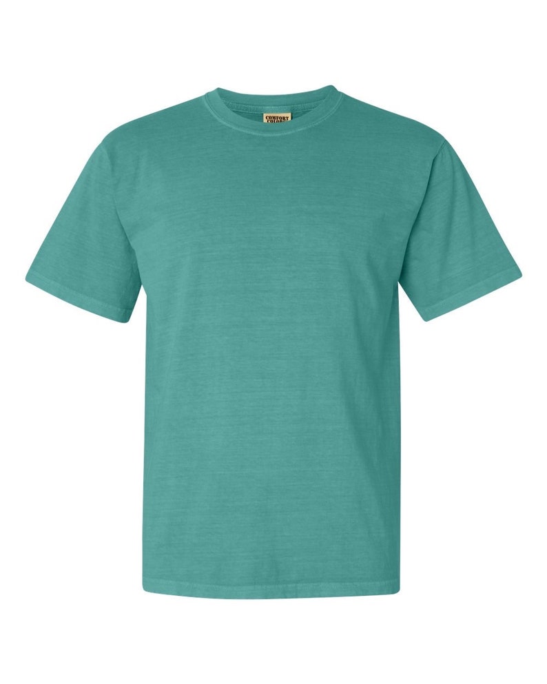 May include: A teal blue short-sleeved t-shirt with a Comfort Colors tag on the front.