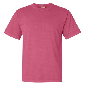 May include: A solid pink short-sleeved t-shirt with a Comfort Colors tag on the front.