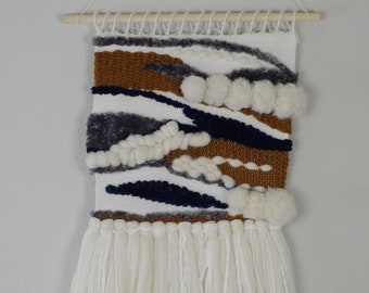 Pequeño tejido con borlas de lana merino