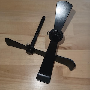 May include: Two black metal hooks with a screw for attaching to a surface. The hooks are designed to hold items like wreaths or other decorative items.