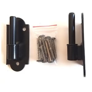 May include: Two black metal gate hinges with a latching mechanism and a set of screws in a clear plastic bag.