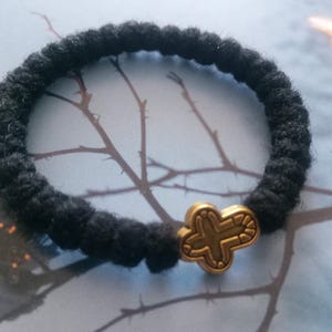 May include: A white ceramic mug with a black handle and the text "But First, Coffee" in a bold, black font. The mug is set against a neutral background, highlighting its simple design.