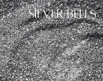 May include: A close-up of a silver glitter fabric with the text "SILVER BELLS" printed in white.