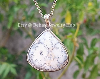 May include: A silver chain necklace with a teardrop-shaped pendant featuring a white and gray dendritic agate stone.