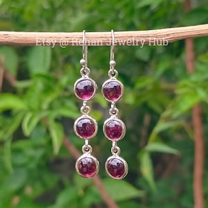 Pode incluir: Brincos de prata com três pedras redondas de cor vermelho escuro. Etsy @ Rehan Jewelry Hub.