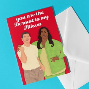 Puede incluir: Una tarjeta roja con un sobre blanco. La tarjeta presenta una ilustración de dibujos animados de un hombre y una mujer con el texto "You are the Dermot to my Alison."