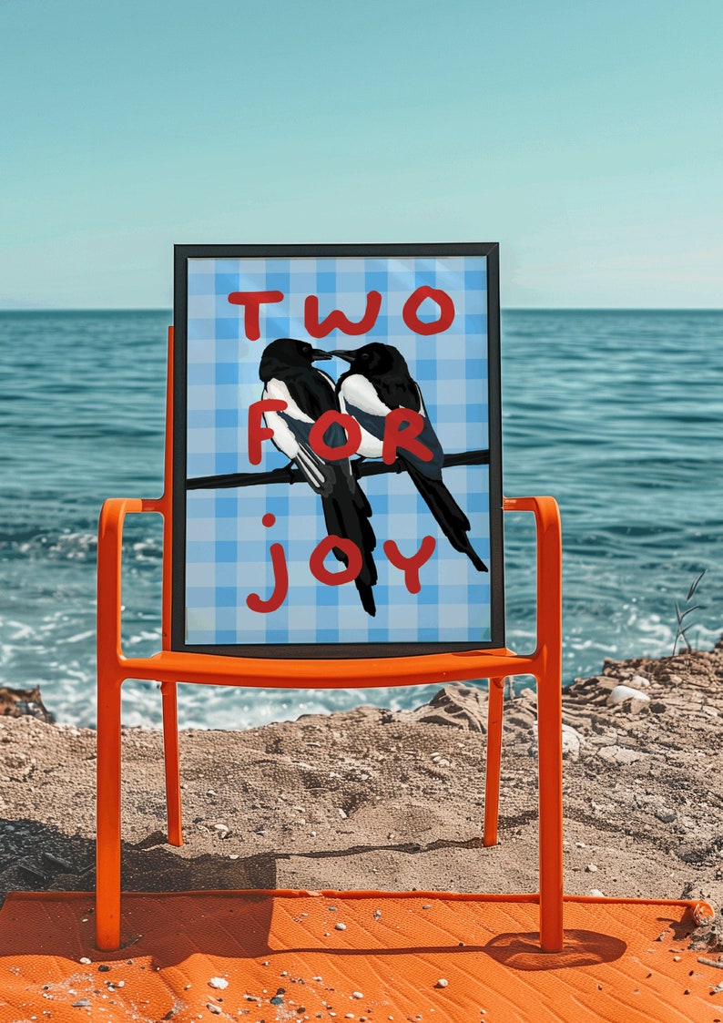 May include: A framed print with a blue and white checkered background. The print features two black and white birds perched on a branch with the words "TWO FOR JOY" written in red.