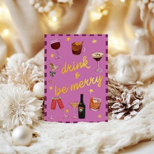 May include: A greeting card with a purple background and the words "drink & be merry" in yellow script. The card features illustrations of various cocktails and drinks, including wine, martinis, and a bottle of liqueur.