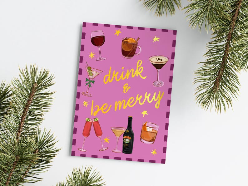 May include: A pink greeting card with the words "drink & be merry" in gold script, surrounded by illustrations of various cocktails and drinks. The card is decorated with small yellow stars and a purple border.