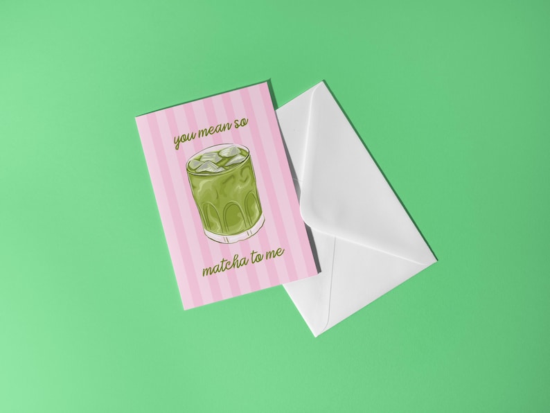 May include: A pink card with vertical white stripes and the text "you mean so matcha to me" next to a white envelope on a green background. The card features a drawing of a matcha drink with ice.