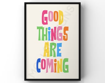 May include: A framed print with the text "GOOD THINGS ARE COMING" in colorful, stylized lettering. The background is a light beige color.