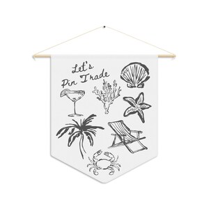 May include: A white pennant banner with black hand-drawn illustrations of a cocktail, palm tree, seashell, starfish, coral, beach chair, and crab. The banner has the text "Let's Pin Trade" written in black.