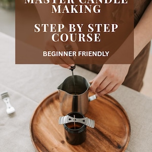 Puede incluir: Una bandeja de madera con suministros para hacer velas: un pequeño frasco negro con un soporte para mecha, una jarra de acero inoxidable y un dispositivo de centrado de mecha blanco. El texto dice "MASTER CANDLE MAKING STEP BY STEP COURSE BEGINNER FRIENDLY".