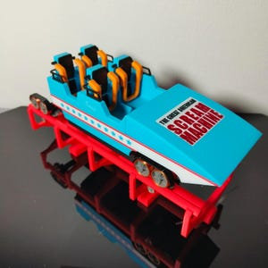 May include: A white ceramic mug with a colourful floral design. The mug has a handle and a wide rim. The flowers are in shades of pink, purple, and yellow. The mug is likely for beverages.