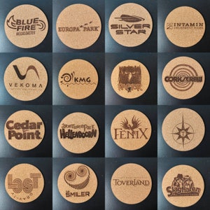 Op de afbeelding: Een verzameling van 16 ronde kurken onderzetters met verschillende logo's van attracties in pretparken, waaronder Blue Fire Megacoaster, Europa Park, Silver Star, Intamin Amusement Rides, Vekoma, KMG, Raptor, Cedar Point, Hellendoorn, Fenix, Toverland, Smiler en Slagharen.