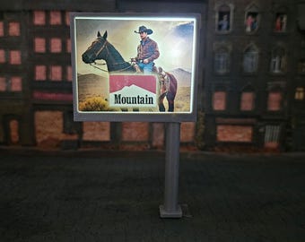 May include: A vintage billboard advertisement for Mountain cigarettes. The billboard features a cowboy riding a brown horse against a blue sky background. The text "Mountain" is displayed in red letters on a white background.