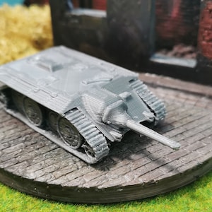 Könnte beinhalten: Ein graues, miniaturisiertes Panzermodell mit detailliertem Design. Der Panzer steht auf einer grauen, strukturierten Basis.