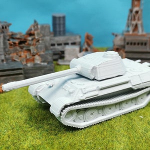Può includere: Un modello di carro armato Panzer IV tedesco in plastica bianca. Il carro armato è su una superficie erbosa verde con sullo sfondo un edificio in rovina.