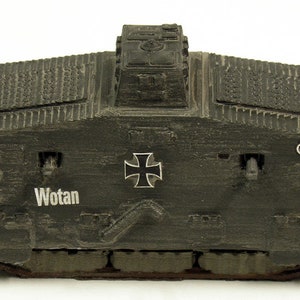 Könnte beinhalten: Ein schwarzes Modell eines deutschen Panzers aus dem Ersten Weltkrieg, der A7V, mit dem Namen "Wotan" auf der Seite. Das Modell hat ein schwarzes Eisernes Kreuz auf der Vorderseite und einen erhöhten Geschützturm oben.