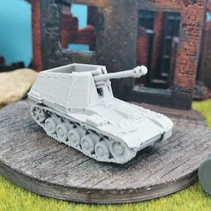 Puede incluir: Un modelo de plástico gris de un cañón autopropulsado alemán de la Segunda Guerra Mundial, el Sturmgeschütz III, sobre una base de madera. El modelo es detallado e incluye el cañón, las orugas y las ruedas.