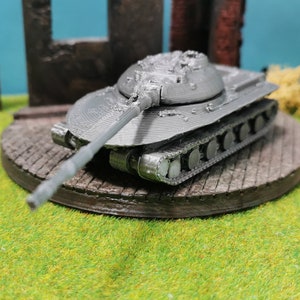 May include: A grey metal model of a tank with a long barrel and tracks. The tank is sitting on a wooden base.