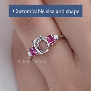 Könnte beinhalten: Ein silberner Ring mit einer anpassbaren ovalen Fassung und zwei rechteckigen rosafarbenen Edelsteinen auf jeder Seite. Der Ring ist mit kleinen runden Diamanten besetzt. Der Text "TRUE LIGHT DIAMONDS" ist unterhalb des Rings sichtbar. "Anpassbare Größe und Form" steht in blauer Schrift über dem Ring.