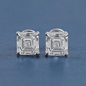 Op de afbeelding: Een paar vierkante diamanten oorbellen met een helder, facetgeslepen ontwerp. De oorbellen zijn gezet in een zilveren zetting.
