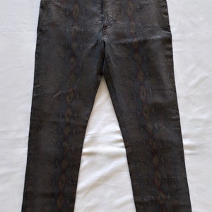 Peut inclure: Un pantalon gris foncé avec un motif de peau de serpent.