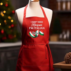 May include: A red apron with the text "I DON'T NEED RECIPES I'M ITALIAN" and the name "Rosa" in white. The apron features a ribbon with the colors of the Italian flag. It has a front pocket and neck and waist ties.