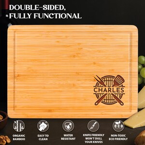 Puede incluir: Tabla de cortar rectangular de bamb&uacute; con ranura para jugos. La tabla presenta texto grabado y un dise&ntilde;o tem&aacute;tico de barbacoa con el nombre "CHARLES". El texto "DOUBLE-SIDED, FULLY FUNCTIONAL" est&aacute; en la parte superior. Iconos indican caracter&iacute;sticas como "ORGANIC BAMBOO".