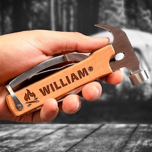 May include: A wooden handled multi-tool with a hammer head, a knife blade, and a bottle opener. The handle is engraved with the name "WILLIAM" and a campfire graphic.
