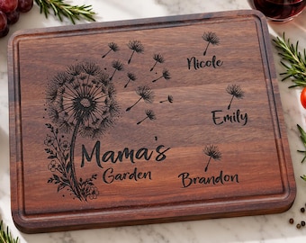 Könnte beinhalten: Ein rechteckiges Schneidebrett aus dunklem Holz mit einer lasergravierten Pusteblume und fliegenden Samen. Der Text lautet Mama's Garden, ergänzt durch die Namen Nicole, Emily und Brandon neben einzelnen Samenkapseln.