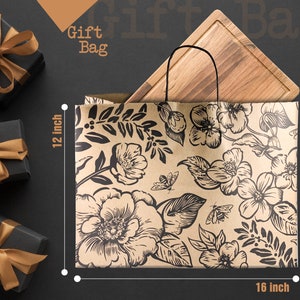May include: A kraft paper gift bag with a floral and bee pattern, measuring 16 inches wide and 12 inches high. A wooden cutting board is inside the bag. The words "Gift Bag" are at the top. Black gift boxes with gold ribbons are in the background.