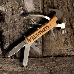 May include: A multi-tool with a wooden handle engraved with the name "MATTHEW". The tool has a knife blade, a hammer, a saw, a screwdriver, and a bottle opener.