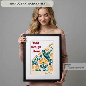 May include: A framed artwork with a black border, featuring a floral design in orange, teal, and cream colors. The text "Your Design Here" is visible, along with "NEW YORK" at the bottom. The top banner reads "SELL YOUR ARTWORK FASTER".